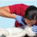 woman performing CPR on baby mannequin