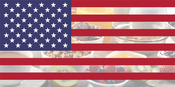 The United States Flag with a faded image of a table filled with breakfast food.