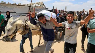 Palestinians carry aid supplies they received from the US-backed Gaza Humanitarian Foundation in Khan Younis, southern Gaza Strip, on May 28, 2025.