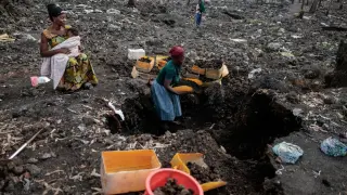 Kahindo, an internally displaced woman, collects volcanic gravel to sell in the Lushagala IDP camp, near Goma.