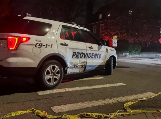A police car passes police tape in the street following a shooting at Brown University in Providence.