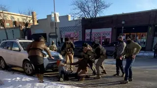 A police officer tries to restrain Alex Pretti to arrest him in Minneapolis.
