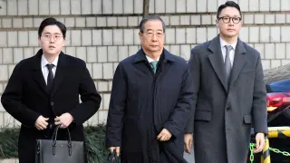 Former South Korean Prime Minister Han Duck-soo, center, upon arrival at the Seoul court this Wednesday to hear the sentence.